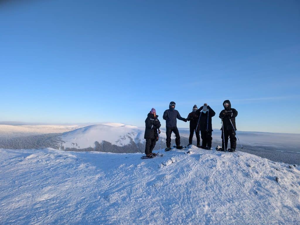 Enjoying a winter hike on snow-covered terrain with a group of people in Ylläsjärvi, Finnish Lapland.