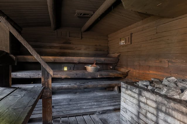 Authentic Finnish sauna with wooden benches and a heater for relaxing in Lapland.