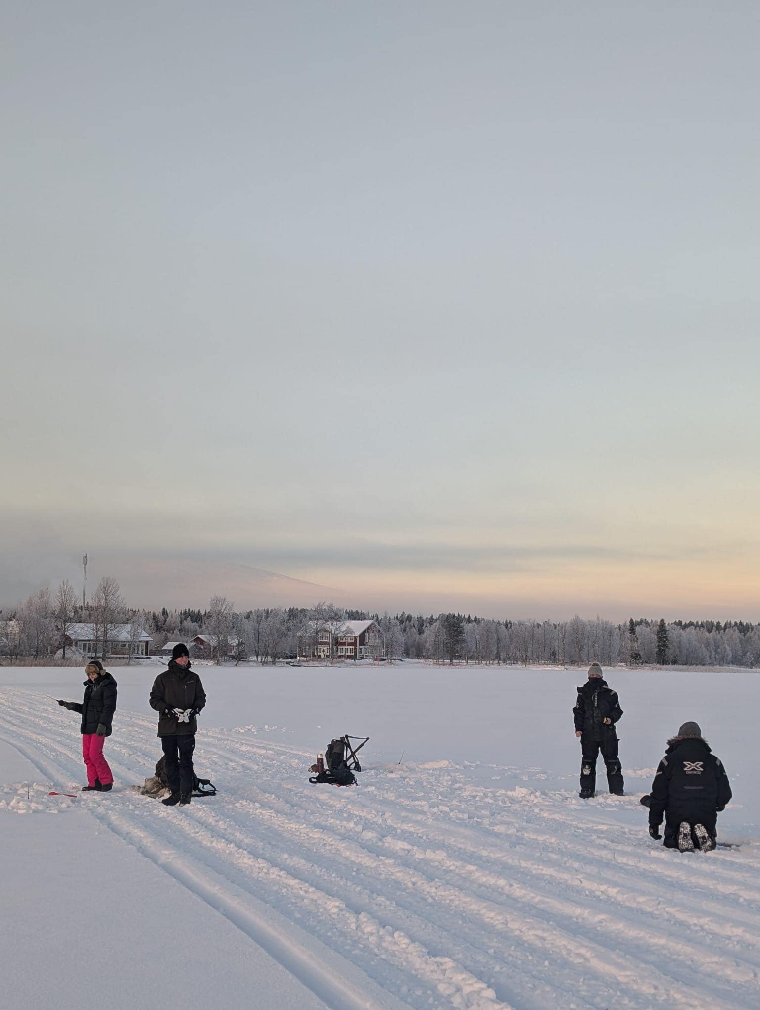 Guests walking to an ice fishing spot on Lake Ylläsjärvi