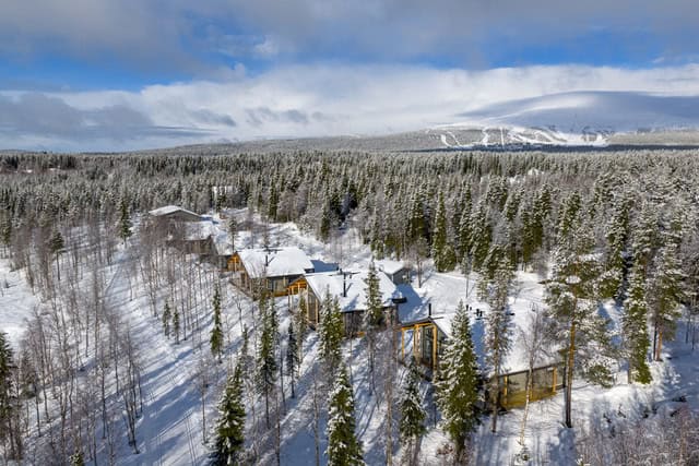 Miilu Resort lodging, snow-covered cabins in a forested landscape in Ylläs, Finnish Lapland