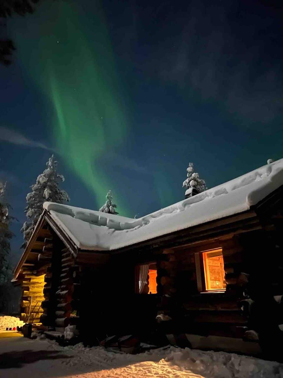 Furu Cabins, northern lights over a snow-covered log cabin in Ylläsjärvi, Finnish Lapland